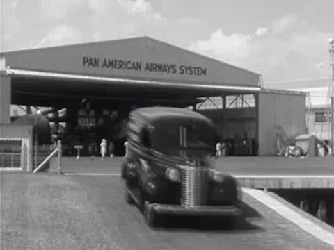 Pan American Airways System building exterior, delivery van drives up.