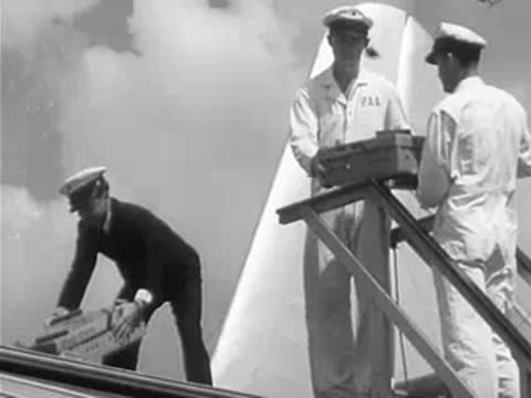 Men load boxes onto a seaplane via stairs.
