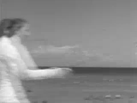 Fencer turning around on sandy beach with ocean in background