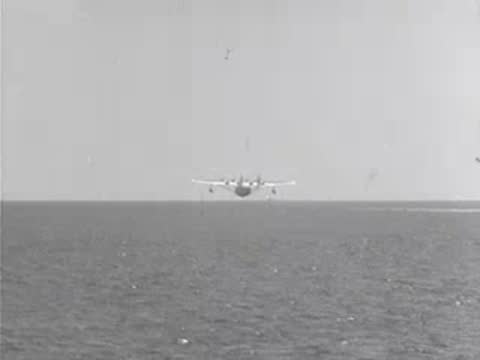Pan American seaplane flies away in the distance over water.