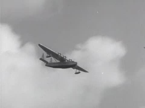 Seaplane flies through the air among clouds.