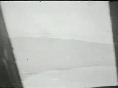 An aerial view looking out a side window of an aircraft in flight.