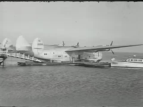 Seaplane moored on water with wooden pier structure.