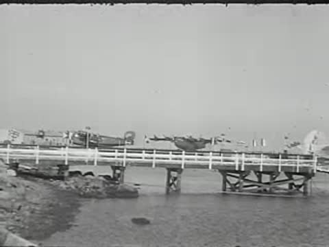 View from a bridge across water with airplanes in distance.