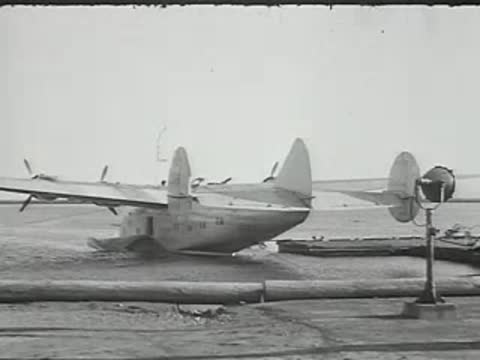Seaplane on water and TWA commercial airliner being serviced.