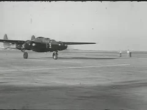 Military aircraft taxiing on an airfield runway.