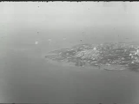Aerial shot of coastal land and a boat on water.