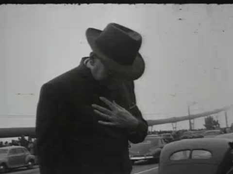 man wearing hat and dark coat standing outdoors