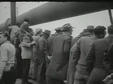 crowd of people standing along a bridge railing