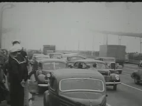 cars parked on a road with people standing nearby