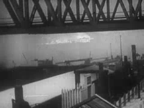 Bridge structure over water and military transport aircraft flying overhead.