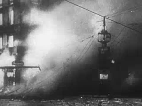 thick smoke and fire billowing on a city street during wartime