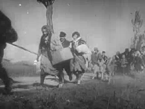refugees with carts and animals walking along a rural road