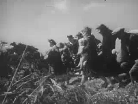people running and diving for cover as an airplane flies overhead