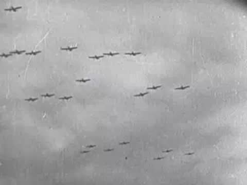 Multiple military airplanes flying in formation across a cloudy sky.