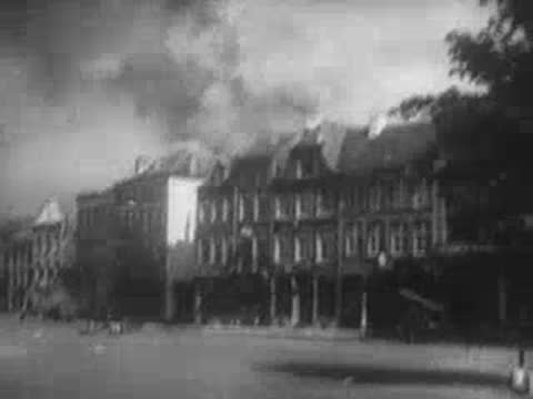 damaged and burning buildings on a deserted city street after an attack