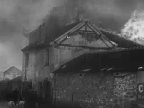 Fire consumes the wooden roof and structure of a traditional stone building.
