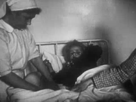 Nurse tends to an injured child lying in a hospital bed.