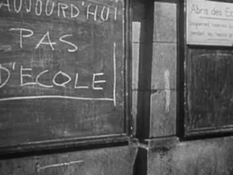 Blackboard outside building reads "AUJOURDHUI PAS D'ECOLE".