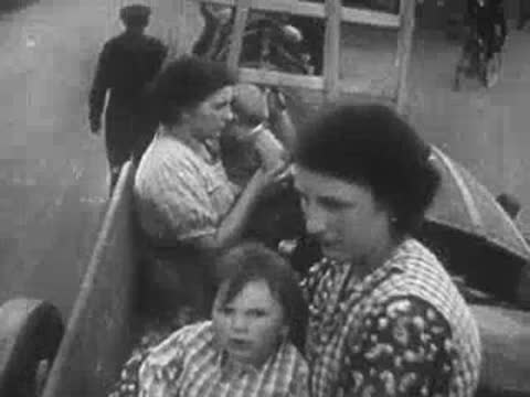 Mother with children and baby carriage outdoors during evacuation.