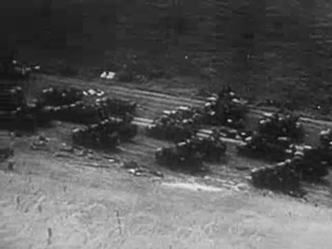 Aerial view of a long military convoy of trucks and vehicles halted.