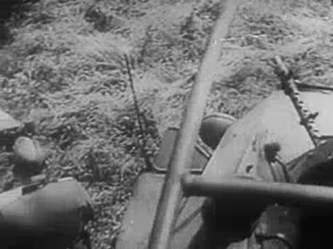 Soldiers in open-top vehicle and on grassy field checking maps, World War II