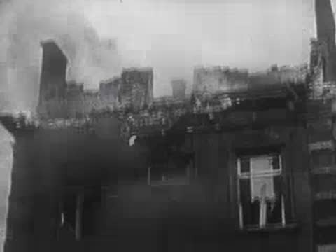 Exterior view of a multi-story building on fire with burning windows.