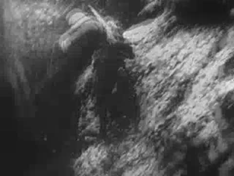 Soldiers running and traversing a muddy trench or crater system, World War II