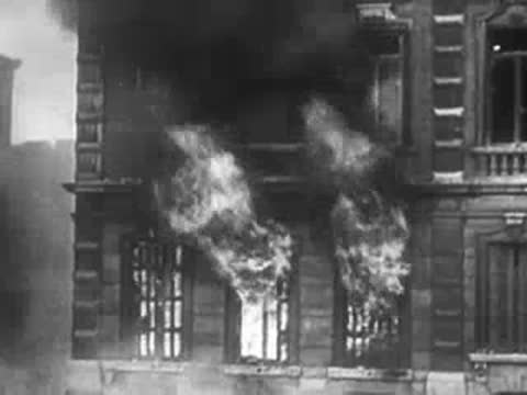 Close-up of a burning building with flames leaping from windows.