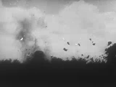 Explosions erupting with debris flying through the air near a treeline, World War II