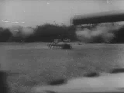 Panzer tank maneuvering past trees and foliage in a field, World War II