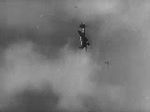 A military aircraft diving steeply through the air in a combat maneuver.