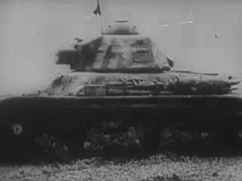 A rocket launcher and a military tank stationed in a field.