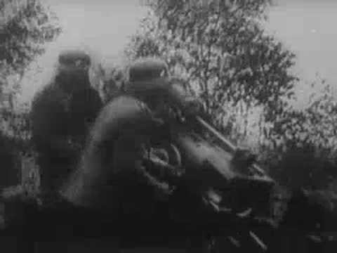 German soldiers operating field artillery and cannons firing across an open landscape.