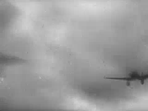 Multiple military aircraft flying in formation low over clouds.