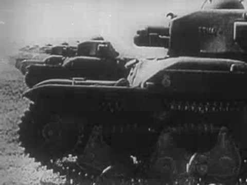 Distant explosions on the horizon and line of military tanks moving across land.