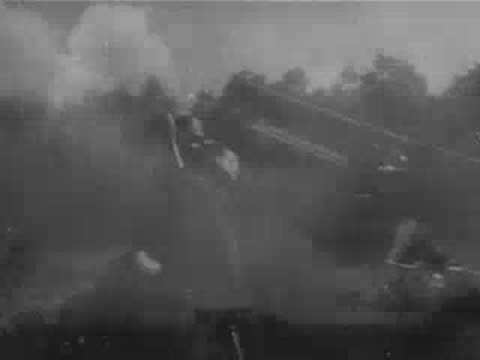 Multiple artillery pieces firing and large smoke clouds billowing across a landscape.