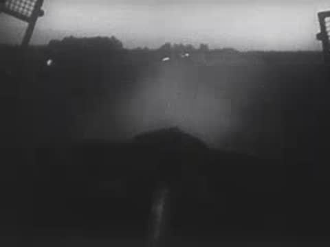 Smoke or fog rising over a dark landscape viewed from behind a structure.