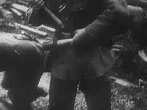 A German soldier preparing grenades in a trench during action.