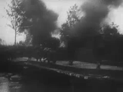 Smoke rising from explosions near a pontoon bridge.