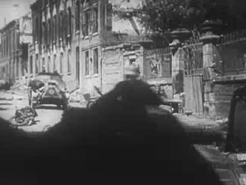 View from a vehicle looking onto a ruined town street.