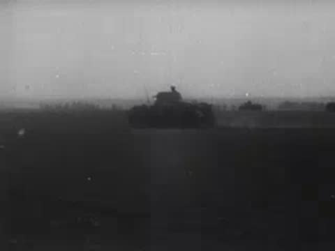 Tanks moving across open terrain in a military formation.