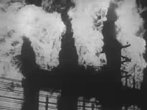 Buildings burning fiercely with thick black smoke billowing into the sky, WWII