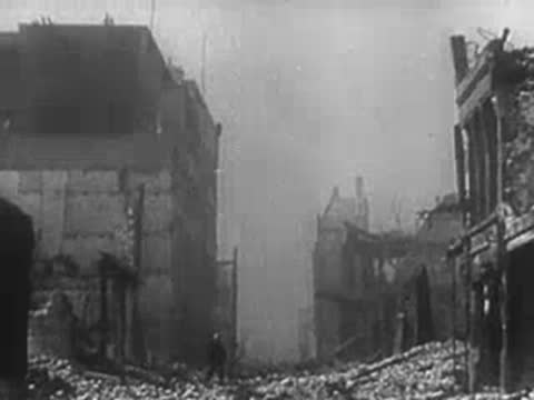 Desolate rubble-strewn street between ruined buildings after a bombing attack, WWII