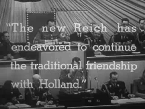 German officials seated at a long table with English subtitles overlaid on screen, WWII