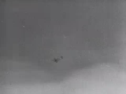 Military aircraft flies through cloudy sky, archive footage