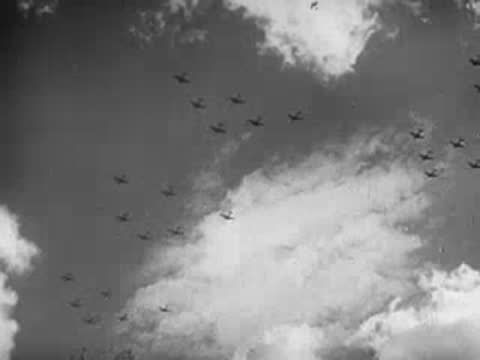 Large formation of military aircraft flying in formation through clouds.