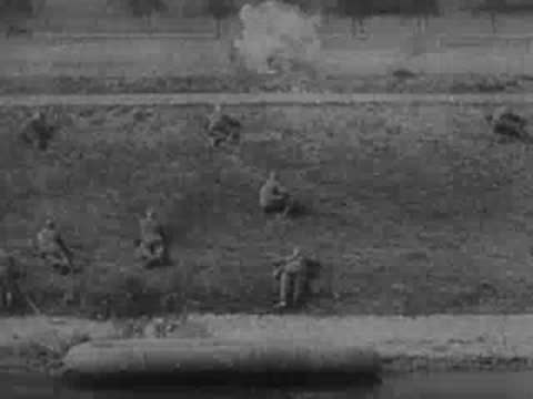 Soldiers lie in grass while aircraft flies overhead, archive footage