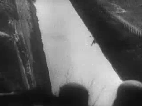 Smoke covers a trench and soldiers look on, archive footage