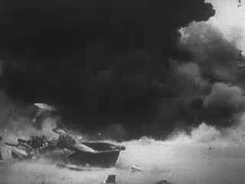 Explosion and heavy smoke near a boat on water.